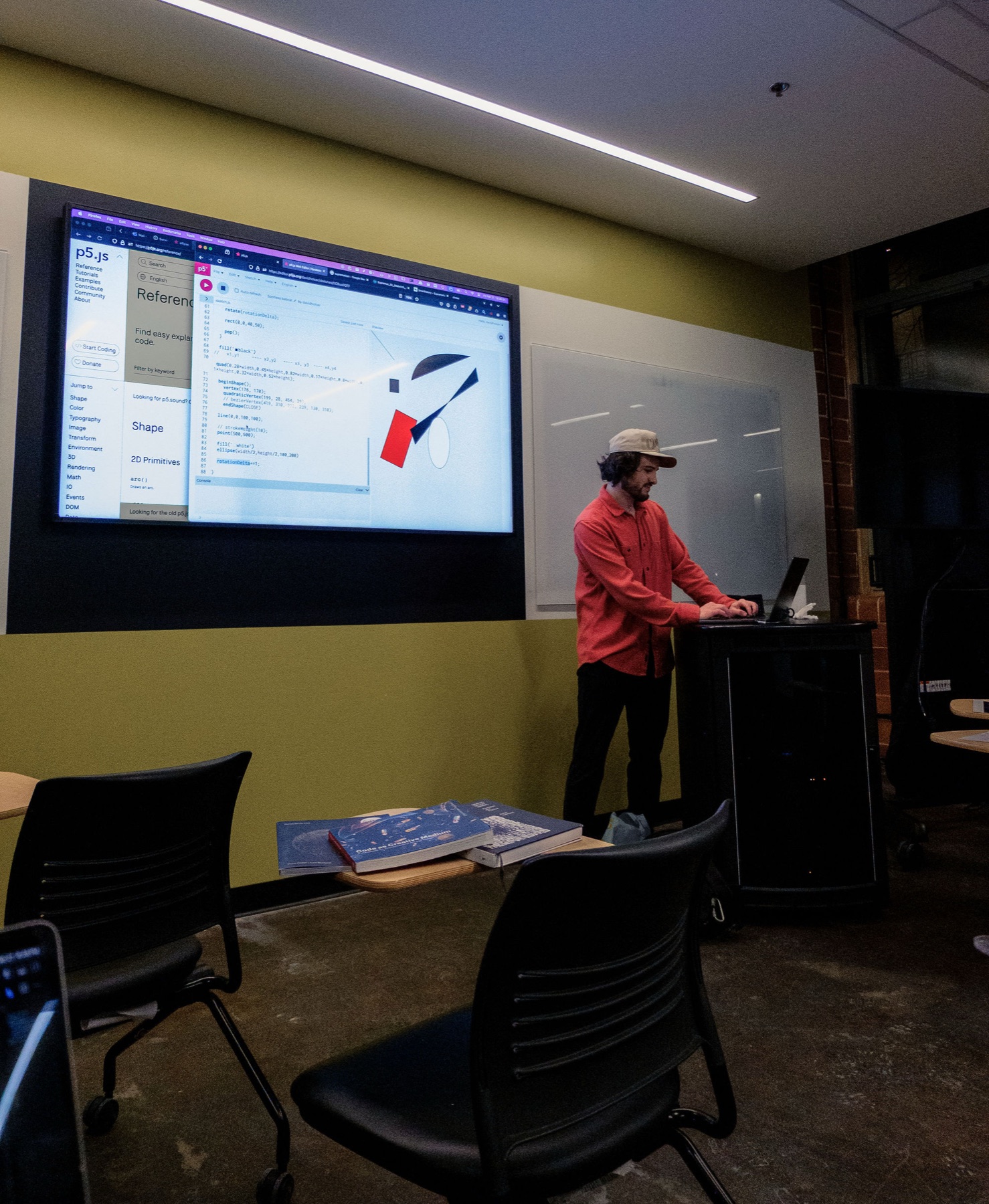 David Holcer live-codes a Suprematist-inspired composition in the p5.js web editor at the lectern