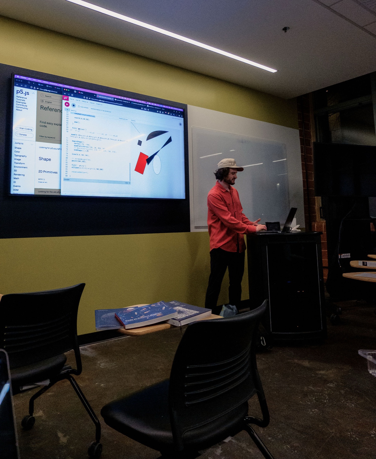 David Holcer adjusts his sketch at the lectern while the composition renders on screen