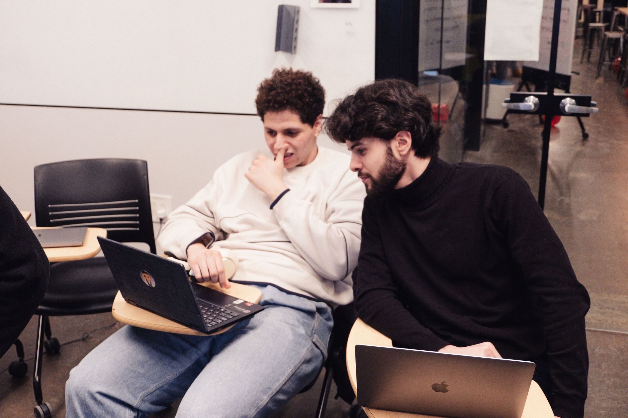 Two participants compare sketches on their laptops