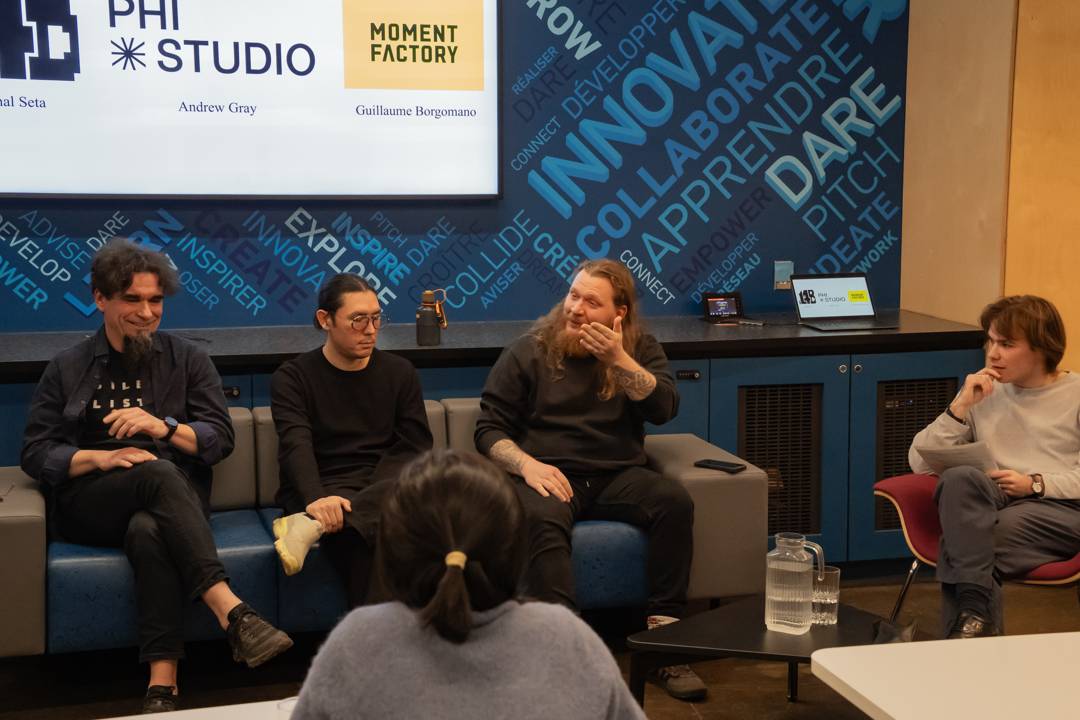 Panelists Michal Seta, Andrew Gray, and Guillaume Borgomano seated with the moderator beneath the title slide